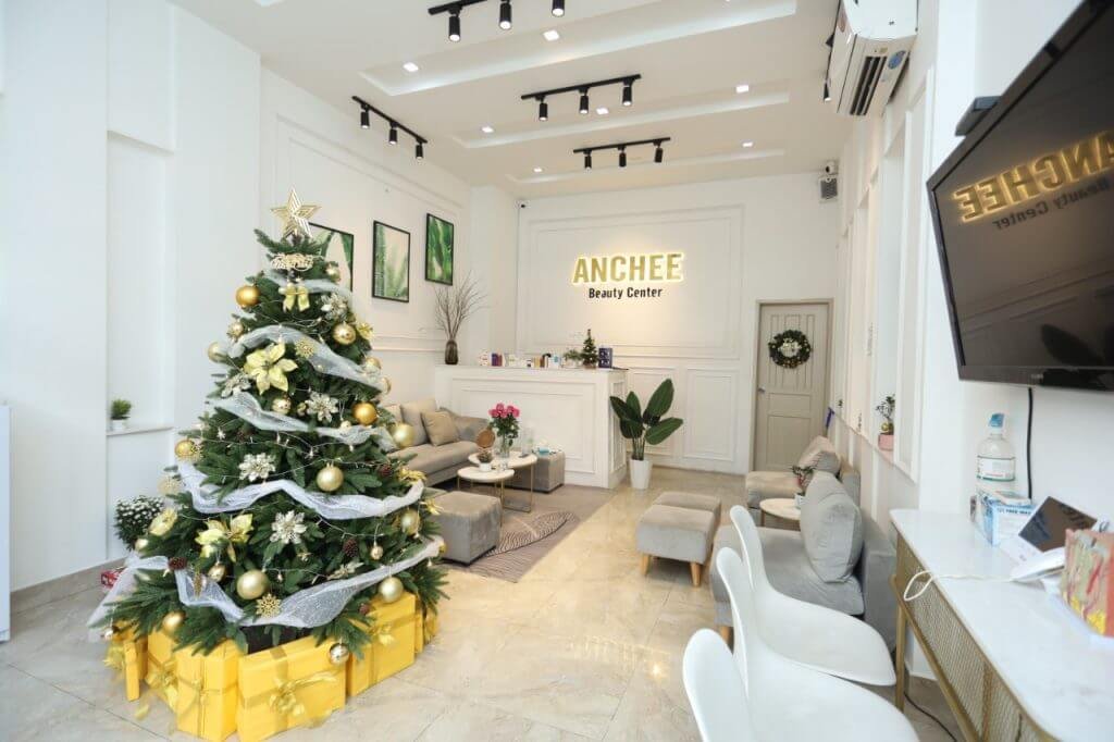 Phòng tiếp khách sang trọng với cây thông Noel trang trí lộng lẫy, nội thất hiện đại và bảng hiệu trung tâm.
