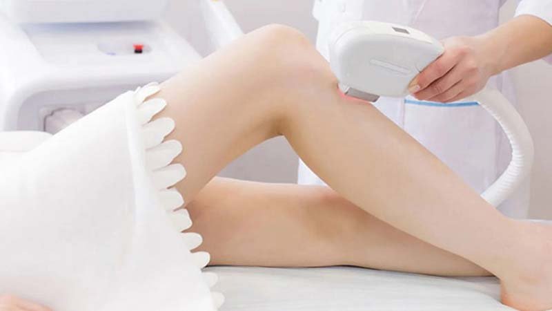 Người đang thực hiện liệu pháp chăm sóc da chân bằng thiết bị chuyên dụng trong môi trường spa.