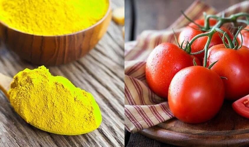 Bột màu vàng và cà chua đỏ tươi trên bàn gỗ, tạo nên sự tương phản màu sắc nổi bật.