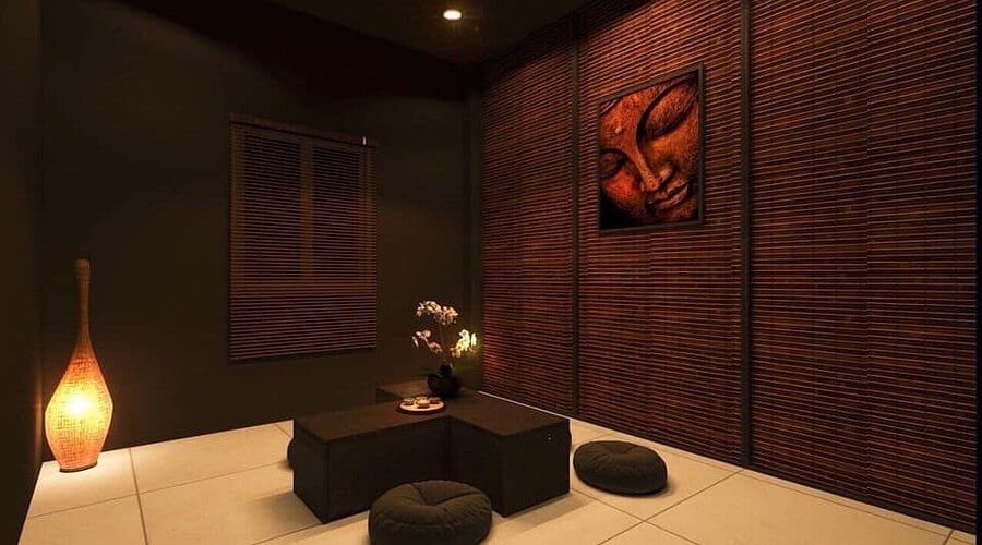 Phòng trà mang phong cách Á Đông với ánh đèn ấm áp, bức tranh tường và bàn trà thấp cùng gối ngồi tròn.